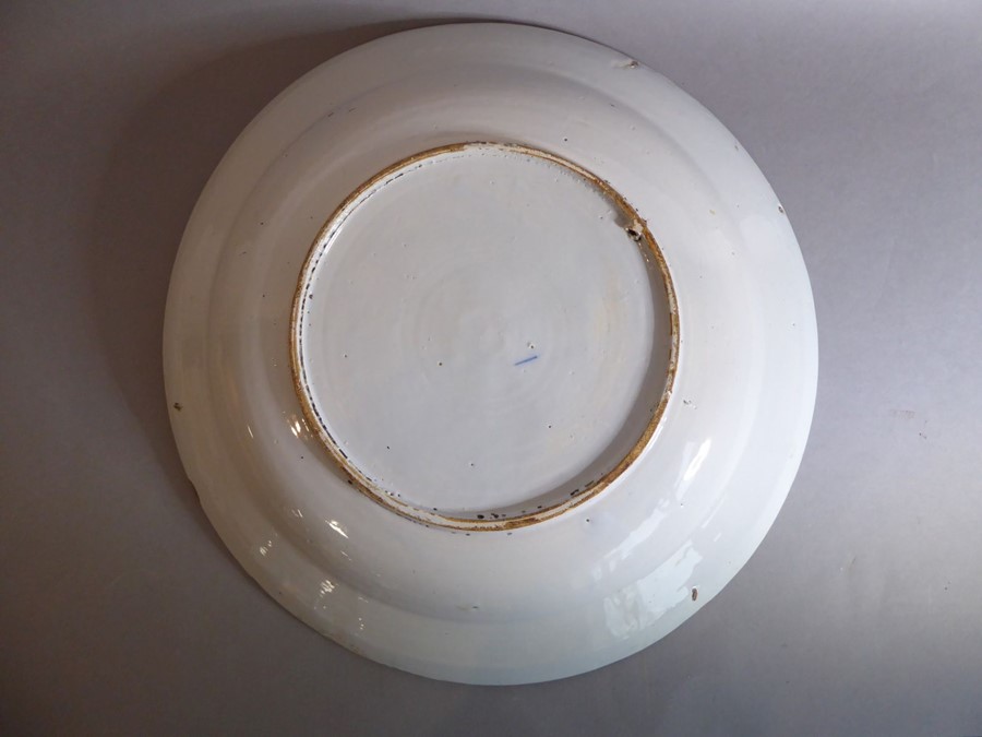A large 18th century circular tin-glazed earthenware dish; hand painted in blue and white - Image 4 of 6