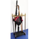An early 20th century six-division brass stick-stand with iron base (62cm high); together with two