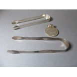Two pairs of late Georgian hallmarked silver sugar tongs and a Maria Theresa silver thaler (
