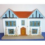 A custom-made hand-painted dolls' house; in early style (probably mid-20th century) double pitched