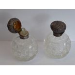 A pair of early 20th century spherical cut-glass silver-mounted scents; the hinged lids decorated in