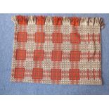 A handmade woollen Welsh blanket with alternating red, cream and salmon-pink square designs (approx.