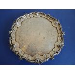 An early Victorian hallmarked silver salver; raised border and with three cast scrolling feet,