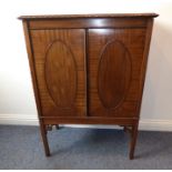 An early 20th century mahogany side cabinet; the gadrooned top above two panelled doors with central
