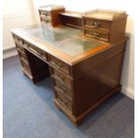 A late 19th century oak pedestal desk; the cross-shaped gilt-tooled green-leather inset moulded top,