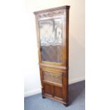 A freestanding reproduction oak corner cupboard; the cornice above a frieze carved with lunettes and