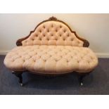 A 19th century button-back upholstered and walnut-framed sofa; foliate carved back rail above