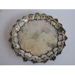 A heavy hallmarked silver salver; foliate-engraving and raised border with shell/leaf-style