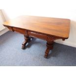 A William IV period rosewood library table; the overhanging top above two cushion-moulded drawers,