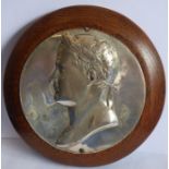 A circular silver-plated bust of Napoleon as Caesar in relief and wearing a laurel wreath; the