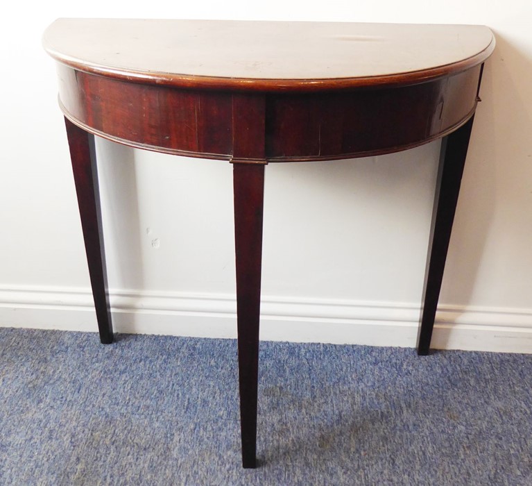 A George III period demi-lune mahogany side table raised on square tapering legs (81cm widest)