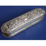 A hallmarked silver oval-shaped box with hinged lid having a vacant cartouche and decorated in