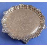 A heavy hallmarked silver salver; raised cast edge decorated with C-scrolls and scallop-shell