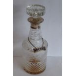 A cut-glass cylindrical decanter with mushroom-style stopper and hallmarked silver neck, also with