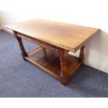 A good reproduction oak coffee table; the moulded overhanging top above gun-barrel style supports