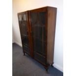 A 1920s/1930s two-door walnut display cabinet; pagoda-style astragal glazing bars and raised on