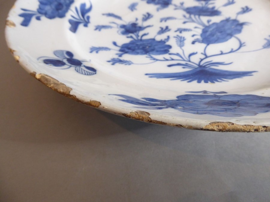 A large 18th century circular tin-glazed earthenware dish; hand painted in blue and white - Image 3 of 6
