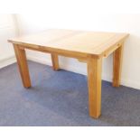 A modern extending light-oak dining table; thick cleated top and square slightly tapering legs,