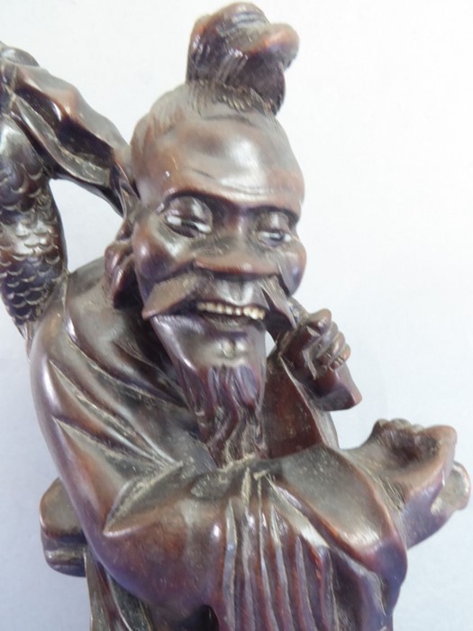 A late 19th century well patinated Chinese hardwood carving of a smiling fisherman (small crack to - Image 5 of 8