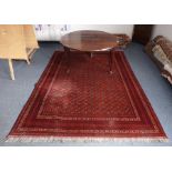 A large and finely handknotted red ground Bokhara-style carpet; the central rectangle surrounded