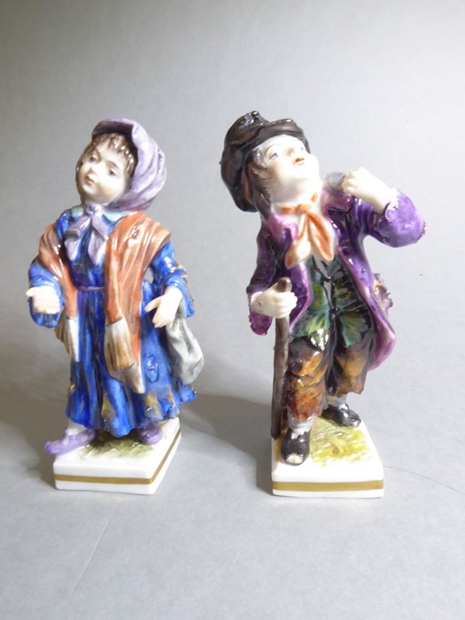 A pair of late 19th century hand-decorated Volkstedt (German) porcelain figure models of a young boy