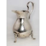 A silver cream jug on three animal's paw feet, assay mark London 1910