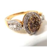 A lady's 9-carat yellow gold dress ring; central oval set with brown diamonds and surrounded by a