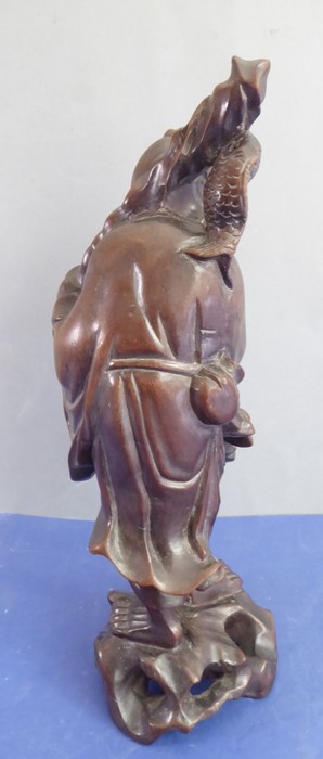 A late 19th century well patinated Chinese hardwood carving of a smiling fisherman (small crack to - Image 4 of 8