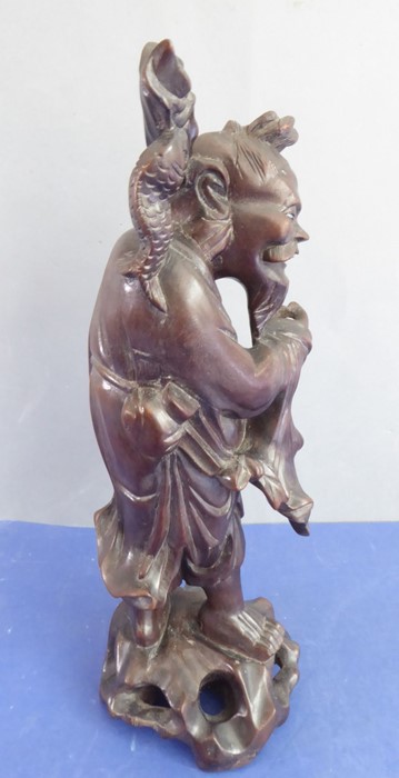 A late 19th century well patinated Chinese hardwood carving of a smiling fisherman (small crack to - Image 3 of 8