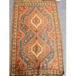 A mid-20th century handknotted Kazak-style rug; two central lozenges against blue, red and cream