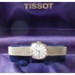 A 9-carat yellow-gold lady's wristwatch by Tissot, the circular white dial signed 'Tissot' and '