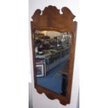 An early 18th century style (probably 19th century) walnut-framed wall-hanging looking glass; shaped
