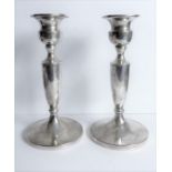 A pair of early 20th century hallmarked silver table candlesticks; hallmarks rubbed but probably