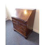 A good early 20th century walnut veneered writing bureau of small proportions; the cross- and