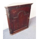 An 18th century (circa 1760/1770) hanging oak corner cupboard; the large arched topped fielded panel