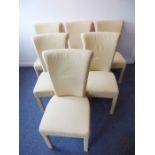 A set of six cream upholstered dining chairs with wide backs and covered upholstered legs complete