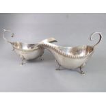 A pair of hallmarked silver sauceboats in Georgian style: gadrooned rims, high arched scrolling