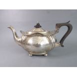 A hallmarked silver teapot of melon form; unengraved cartouche and standing on four bun-style