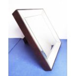 A heavy mahogany-framed easel-style mirror with angular bevelled mirror borders; the back with