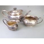 A hallmarked silver three-piece tea service comprising teapot, two-handled sugar and milk jug,