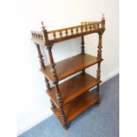 A four-tier walnut whatnot; three-quarter spindle galleried top above shelves and turned supports (