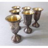 Six small goblets with gilded interiors; their undersides marked 'Sterling' (approx 8cm high)