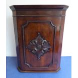 A 19th century mahogany hanging corner cupboard of small proportions; the slightly outset cornice