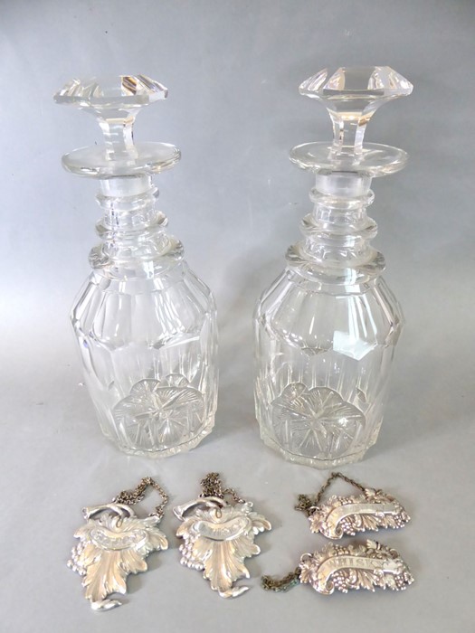 A pair of late Georgian ring-necked cut-glass decanters with original stoppers; together with two