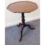 An antique mahogany occasional table; the 19th century pie-crust-edged top above an 18th century