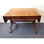 An early 19th century Regency period faded mahogany sofa table; two half-width drawers, two dummy