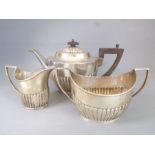 A hallmarked silver three-piece tea service: teapot, two-handled sugar and milk jug; lobed lower