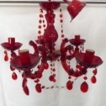 A cranberry-coloured five-light ceiling hanging glass candelabra