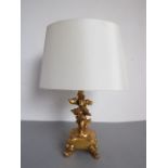 A giltwood table lamp modelled as a cherubic figure playing the violin (32.5cm including shade)