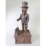 A cast-iron automaton 'Uncle Sam' novelty money box; the press-button action opens the bag and